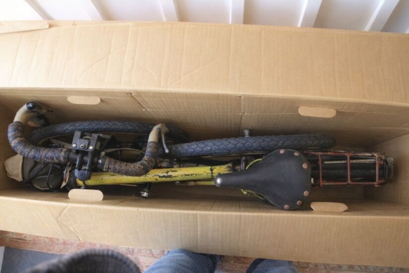 En begagnad cykel packad i en stor kartong för frakt.